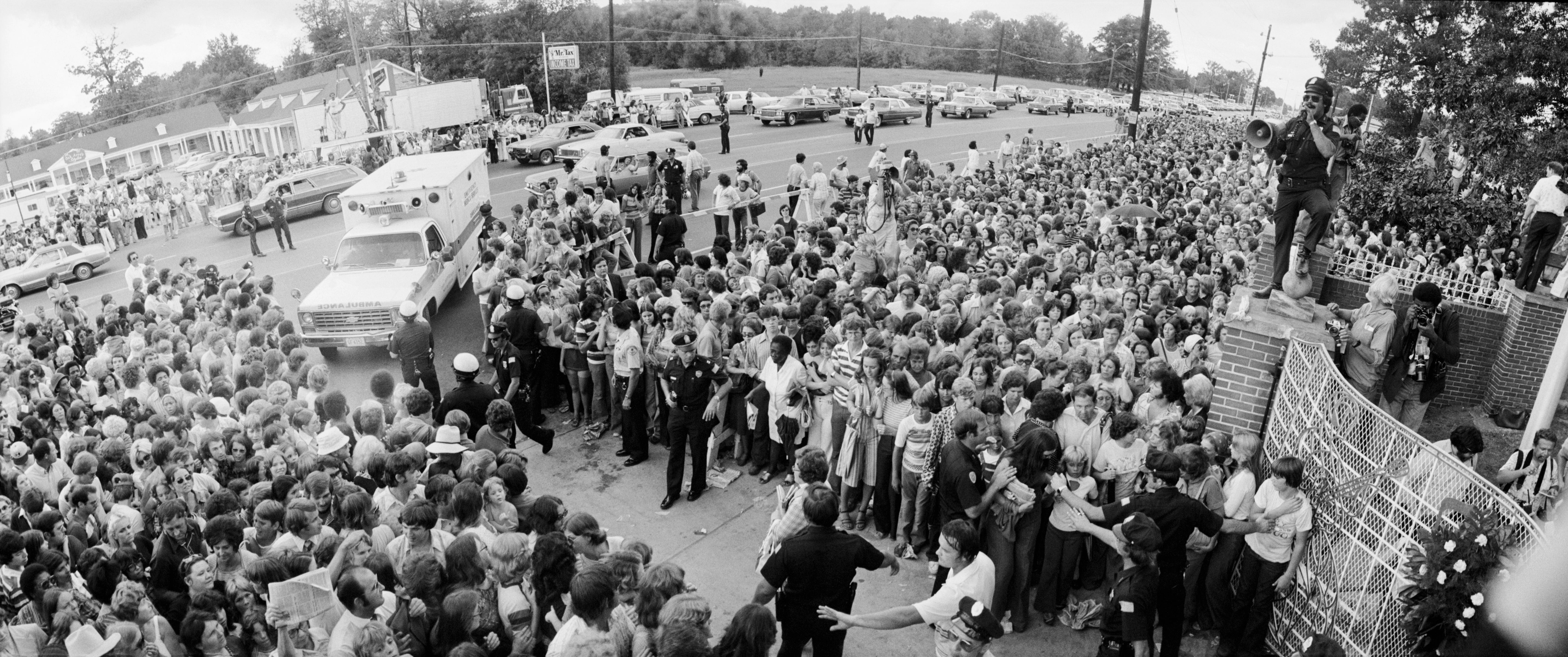 A crowd gathers outside the gates of Graceland, for the funeral of Elvis Presley.