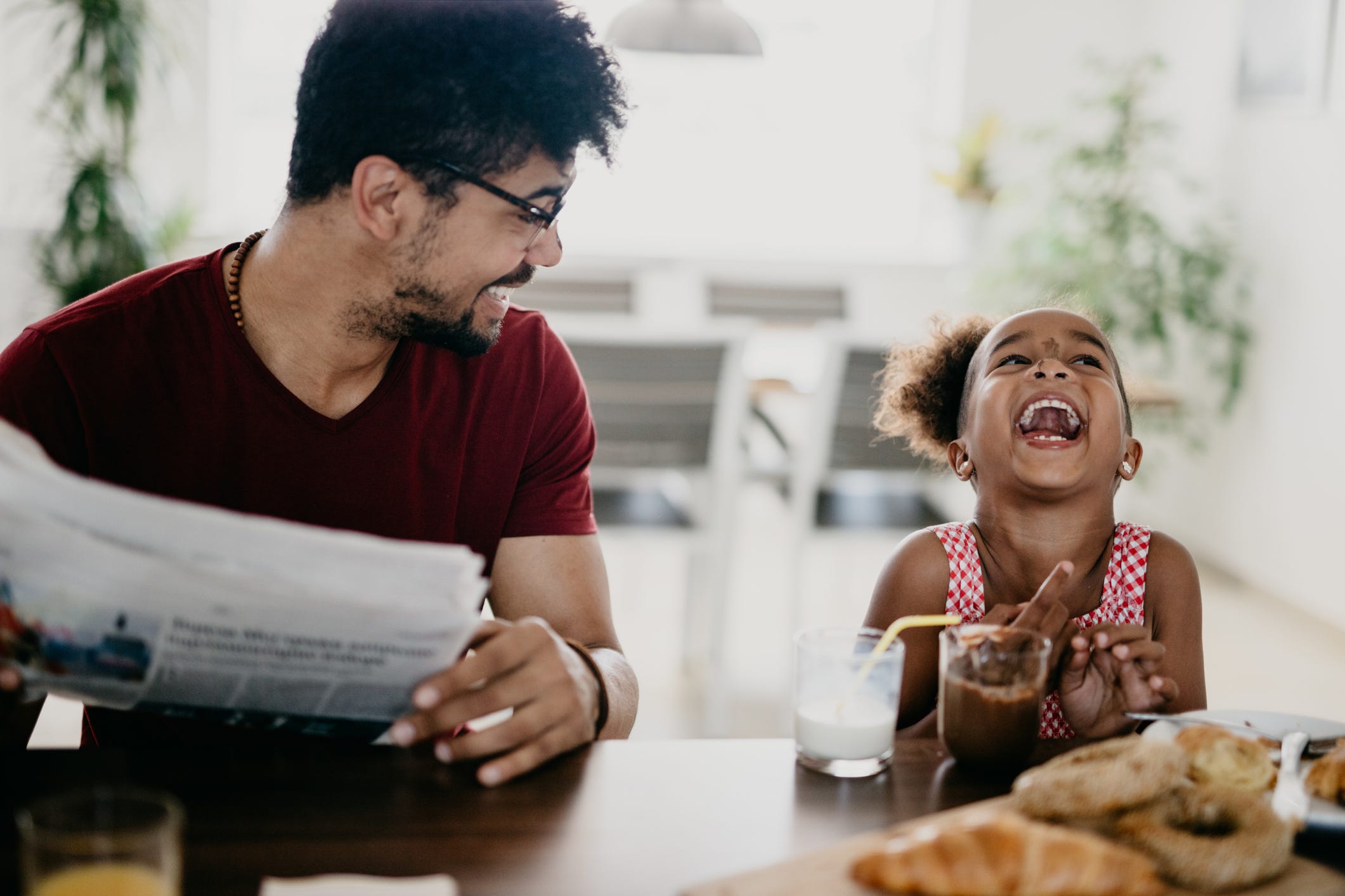 jokes for kids  dad and daughter laughing at kitchen counter over breakfast