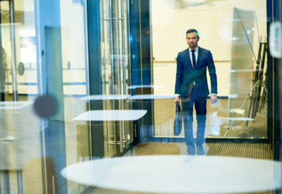 man in professional attire exiting building