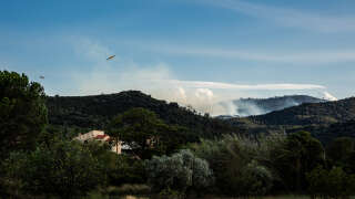 Civil Security Canadair water bomber planes fly over a wildfire in Camelas, near Perpignan, on September 12, 2024. About 800 firefighters have been dispatched to the scene, supported by a dozen helicopters and water-bombing planes at a time when the Pyrénées-Orientales is subject to a severe drought for the third year in a row. (Photo by Jean-Christophe MILHET / AFP)