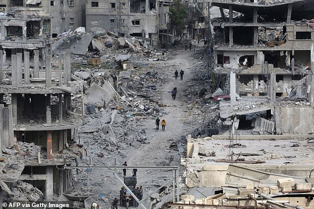 Palestinians walk past damaged buildings in Khan Younis on April 8 2024