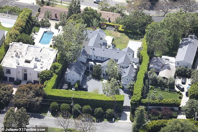 The conservatively styled home features 10,000 square feet of space and his hidden by tall shrubbery and a hill on the other side of the property