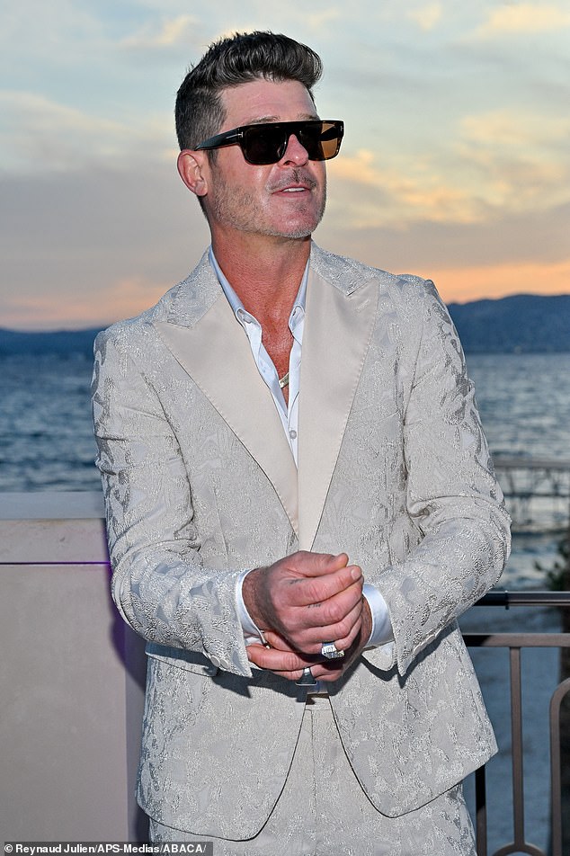 Robin completed his sharp look with a thick silver chain necklace and a pair of black oversized sunglasses