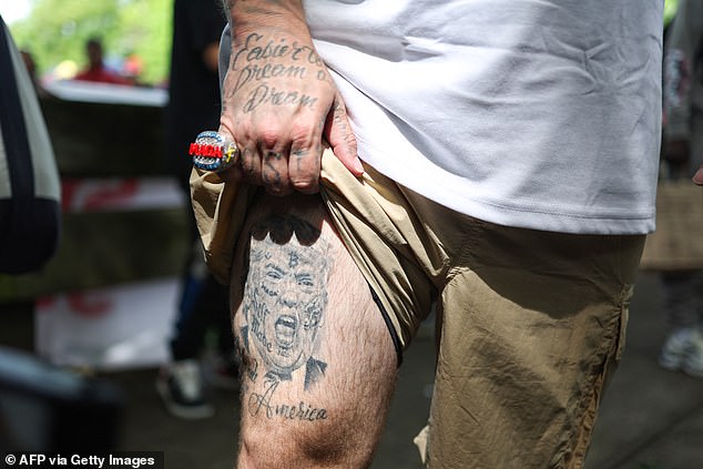 Forgiato Blow shows off his leg tattoo as he joins the crowd before the event on Thursday