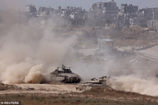 Israeli tank and an APC maneuver inside the Gaza Strip, amid the ongoing conflict between Israel and Hamas, near the Israel-Gaza border, as seen from Israel, June 8, 2024