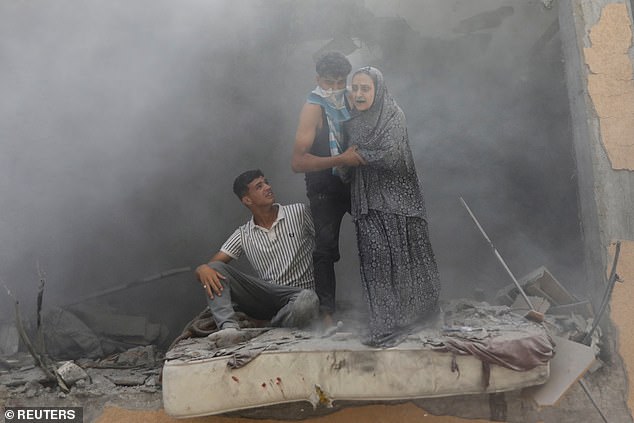 Palestinians react at the site of an Israeli strike on a house, amid the Israel-Hamas conflict, in Deir Al-Balah, in the central Gaza Strip, June 14, 2024