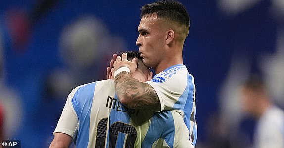 Argentina's Lautaro Martinez, right, embraces teammate Lionel Messi at the end of a Copa America Group A soccer match against Canada in Atlanta, Thursday, June 20, 2024. (AP Photo/Mike Stewart)