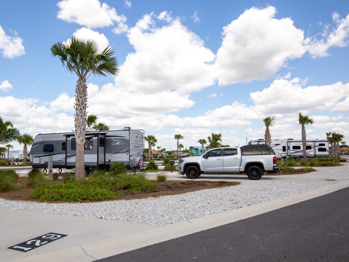 RVs parked at a RV park on a blue sunny day.