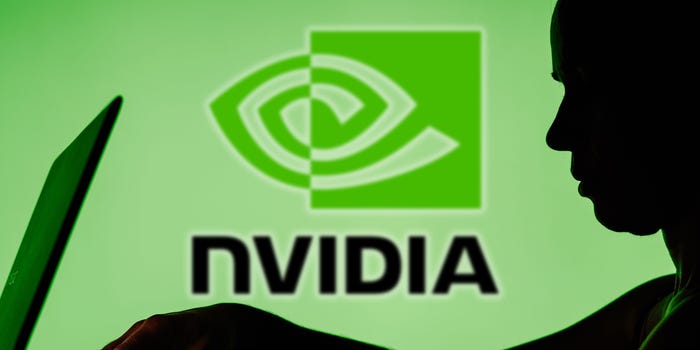 Nvidia logo with a shadow of a person on a laptop in front of it