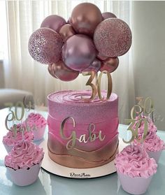 a cake with pink frosting and balloons on top