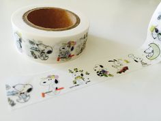 a roll of white washi tape with cartoon dogs on it next to a roll of stickers