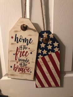 two patriotic tags hanging on a door hanger with the words home of the free because of the brave