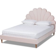 a bed with a pink shell headboard and foot board on it's side