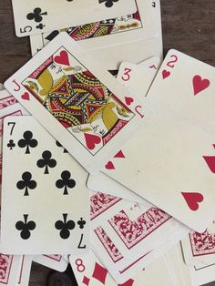 a pile of playing cards sitting on top of a wooden table