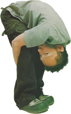 a man bending over with his head on top of another man's leg, wearing green shoes