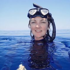 a woman in the water wearing a scuba mask and goggles