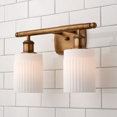 two light bathroom fixture with frosted glass shades on white tile backsplashing