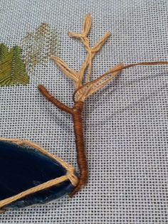 a lizard that is laying down on the ground next to a blue bowl and plant