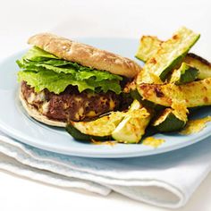 a sandwich and some potato wedges on a blue plate with a white napkin next to it