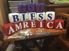 blocks spelling god, bibles, and america sit on a table in front of a chair