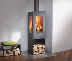 a wood burning stove with logs stacked on the floor