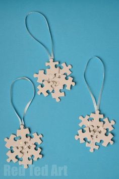 two wooden snowflakes hanging from strings on a blue background