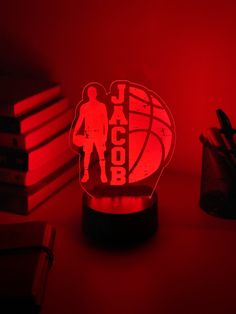 a red light that is on top of a desk with books and pens in front of it