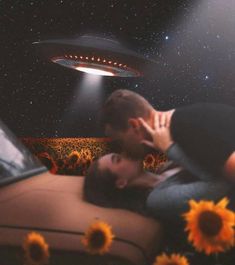 a man and woman kissing in front of a flying saucer above sunflowers