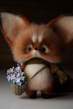 a small stuffed animal with flowers in its hand