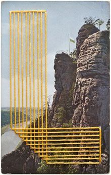 a yellow metal fence sitting on top of a mountain