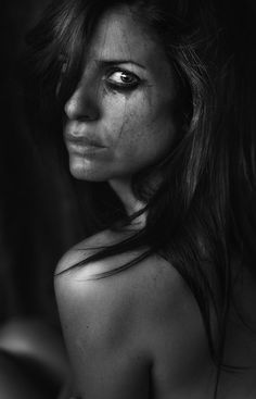 a black and white photo of a woman with freckles on her face, looking at the camera