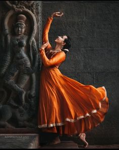 a woman in an orange dress is dancing