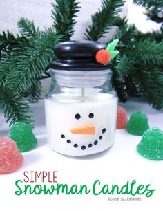 a snowman candle is sitting in front of some pine cones and fir tree branches