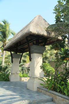 an outdoor gazebo with steps leading up to it and palm trees in the background