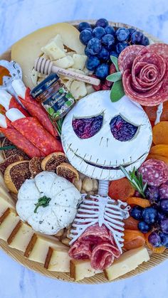 a platter filled with cheese, meats, and other foods that look like jack skellingy face