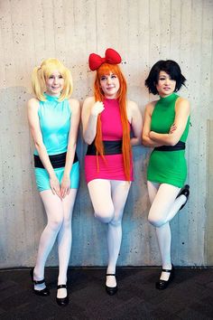 three women dressed in costumes standing next to each other