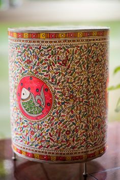 a decorative tin can sitting on top of a wooden table