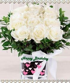 a bouquet of white roses in a vase with a happy birthday message on the side