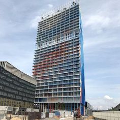 a tall building under construction next to other buildings