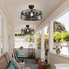 an outdoor porch with wicker furniture and hanging lights