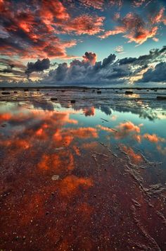 the sky and clouds are reflected in the water