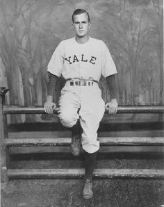 an old black and white photo of a baseball player sitting on a bench in front of a painting