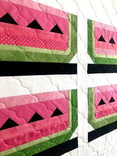 two pink and green quilts are on display