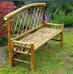 a wooden bench sitting on top of a lush green grass covered park area next to flowers