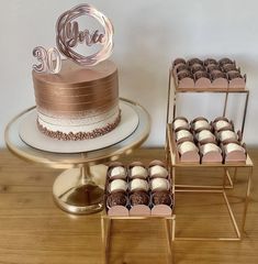 there is a cake, cupcakes and two tiered trays on the table