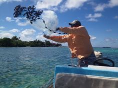 a man on a boat catching something in the air