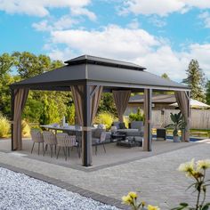 a patio with a table and chairs under a gazebo in the middle of it