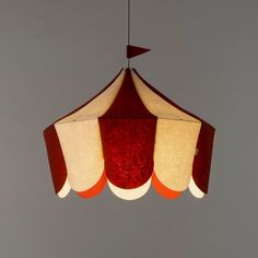 a red and white lamp hanging from a ceiling