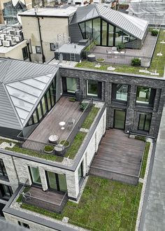 an aerial view of two buildings with grass on the roof and balconyes in front