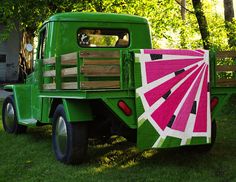 a green truck with a pink fan quilt on the back